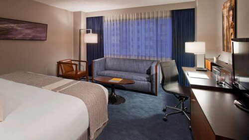 Photo of Hyatt Regency Minneapolis King size bed room showing the end of the bed, couch, and desk