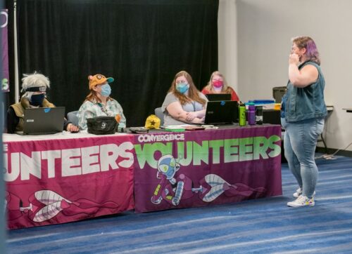 Volunteers table with many friendly staff sitting behind it